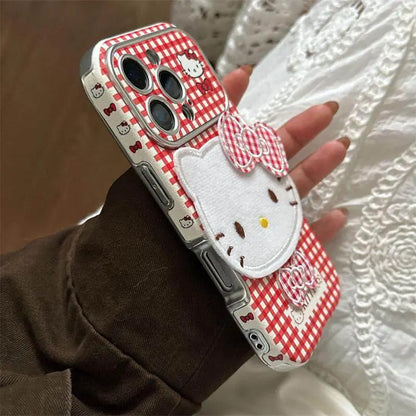 Hello Kitty Red Checkered iPhone Cover with 3D Bow displayed on a hand, featuring a cute design and plush bow accent.